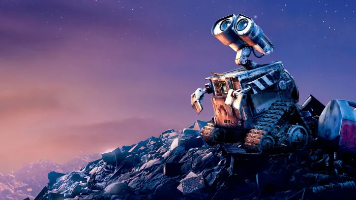 WALL-E perched on a garbage heap, looking up at the sky.
